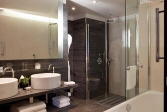 Salle de bain avec douche, baignoire et peignoir