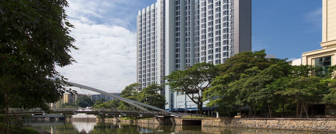 Vista diurna dell’esterno dell'hotel, con il fiume Singapore e il ponte Robertson