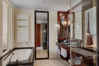Luxuriöses Bad in hellen Farben mit Badewanne und großen Spiegeln