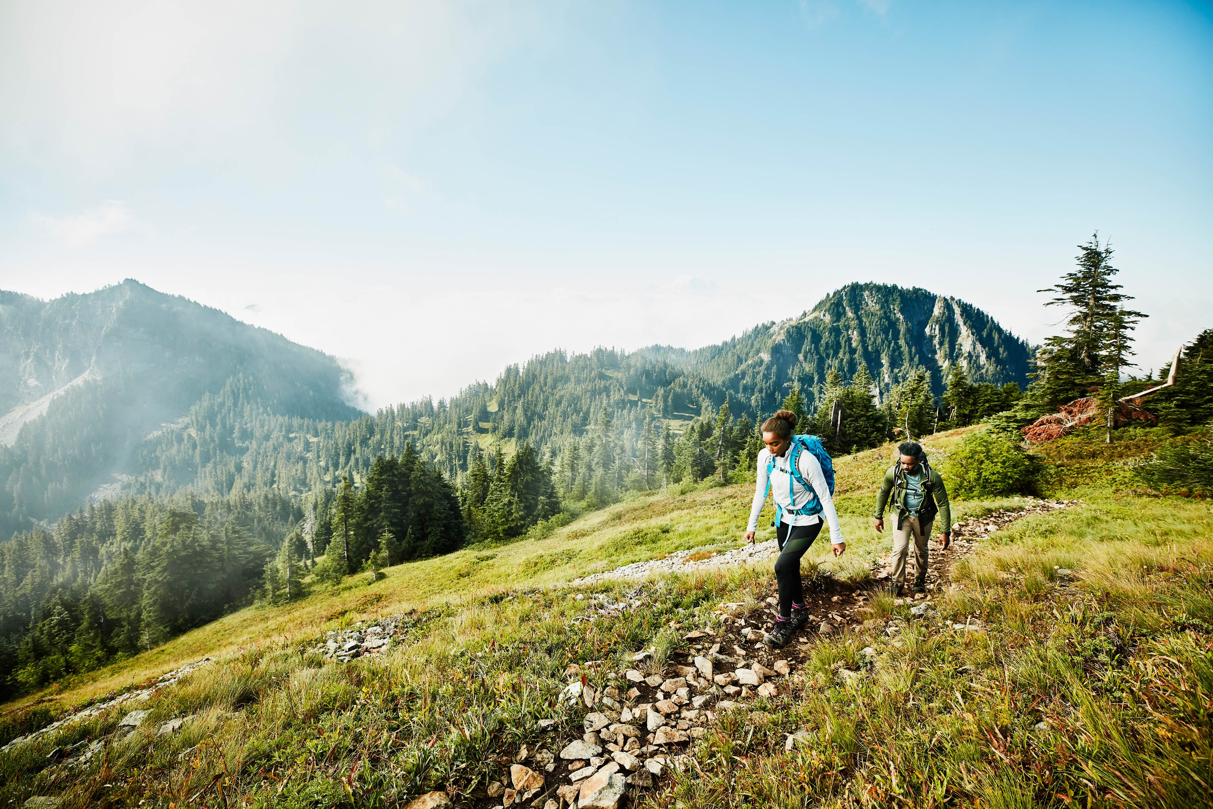 Sporty couple hiking through the mountains near luxury hotel Schloss Fuschl