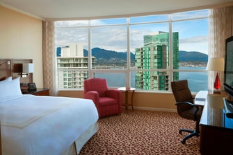 Chambre avec lit king size et vue sur le port à Vancouver